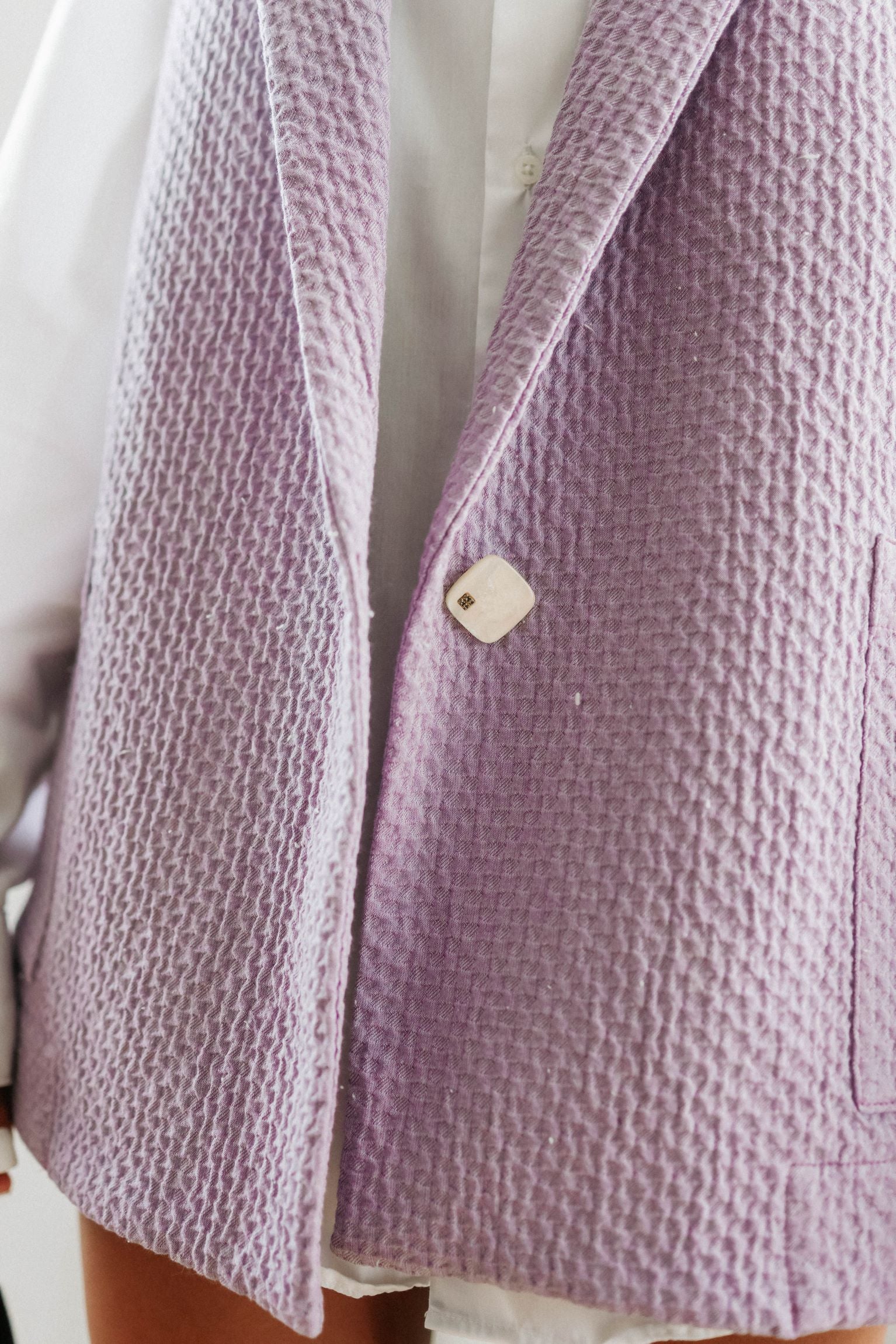 details veste violet costume avec bouton blanc