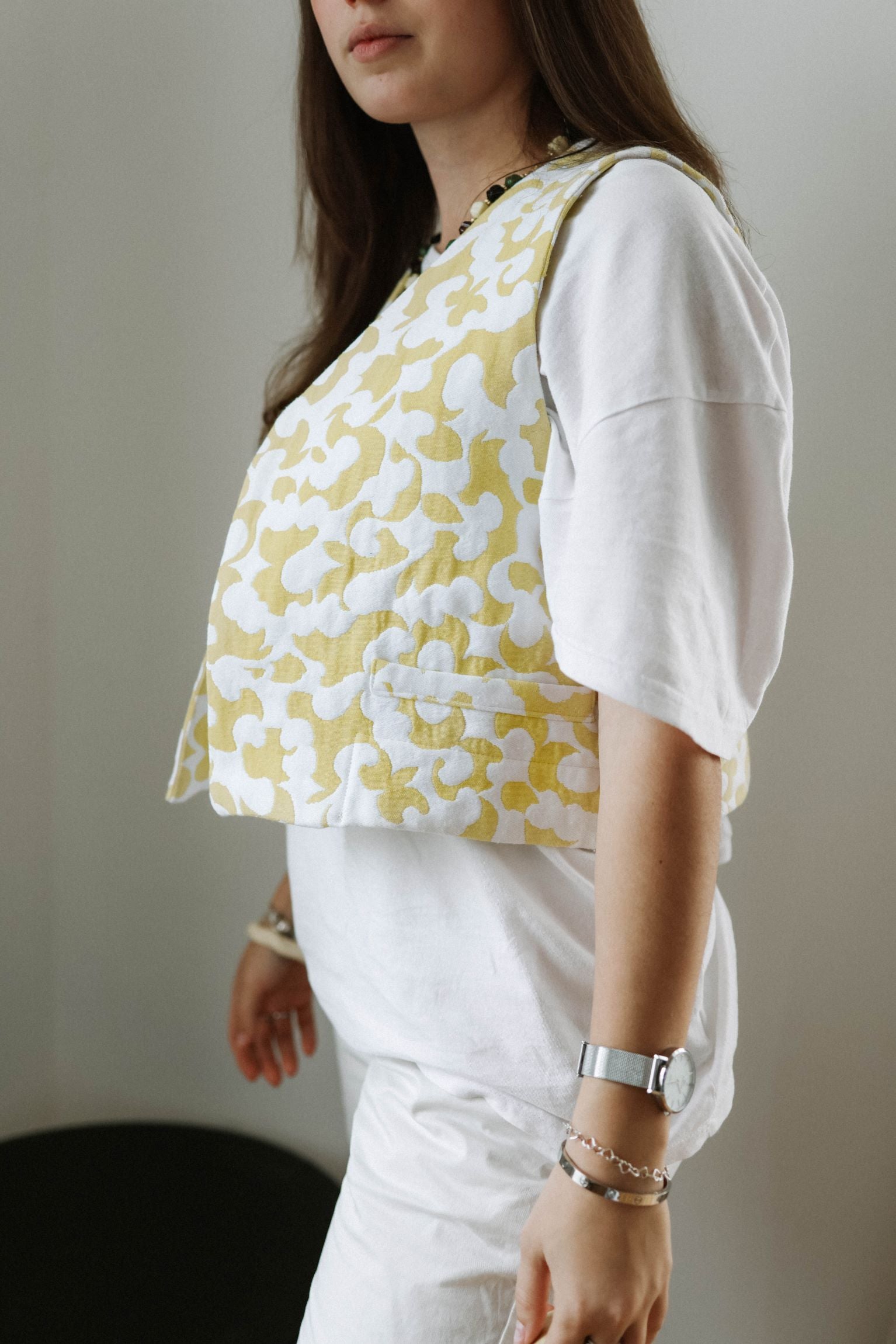 details de la veste courte sans manche by ninette blanche avec des motifs jaune